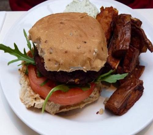 Burger of the day with relish, onion, rocket and tomato, with sweet potato fries and basil mayo  at Mildreds - Soho in London
