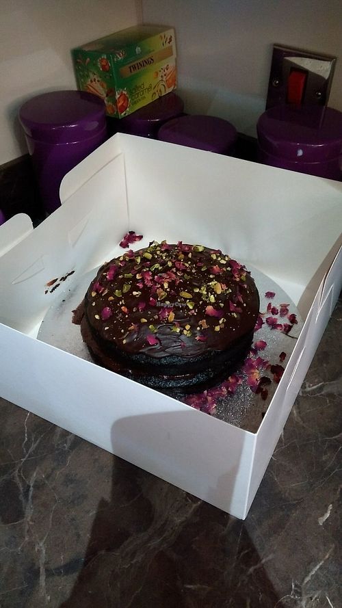 Fantastic vegan chocolate cake decorated with rose petals and pistacio nuts.  at VeGee Deli in Lowestoft