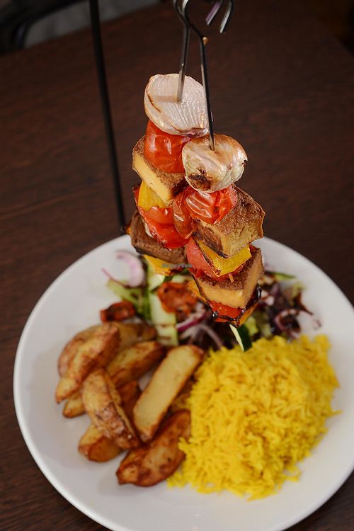 Tofu Hanging Kebabs! Devons Dragonfly Farm marinated Tofu kebabs served skewered with cherry tomatoes, peppers, onions above rice, homemade wedges & salad garnish at Rock Garden in Torquay