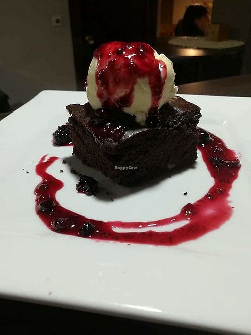 Brownie de chocolate con helado de mango y salsa de frutos del bosque. 100% vegano  at Tommate in Galapagar