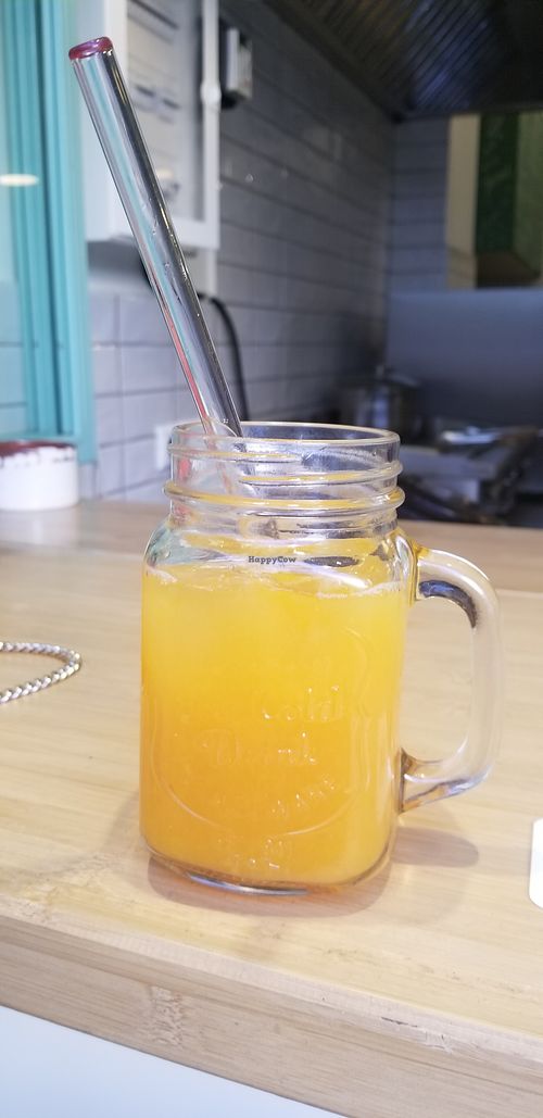 Orange juice with glass straw at Peas in Athens