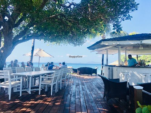 Outdoor seating by the beach  at Cotton House Beach Cafe in Mustique