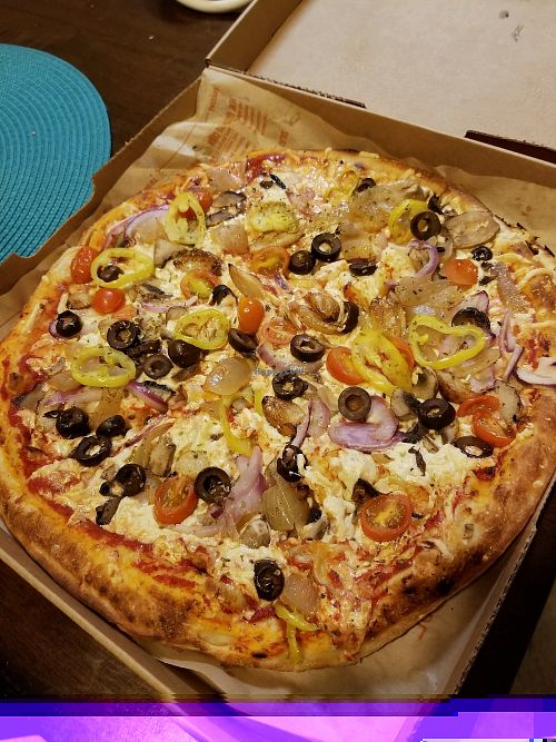 Double crust with red sauce, Daiya, tomatoes, banana pepper, olives, sauteed onion, red onion, mushroom, roasted garlic pizza at Blaze Pizza in Normal