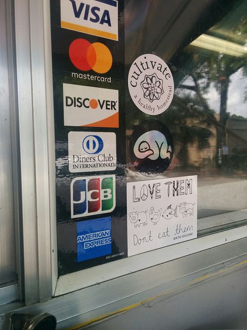Adding a Happy Cow approved sticker to the Food Trucks window at Murray Hillbilly in Jacksonville