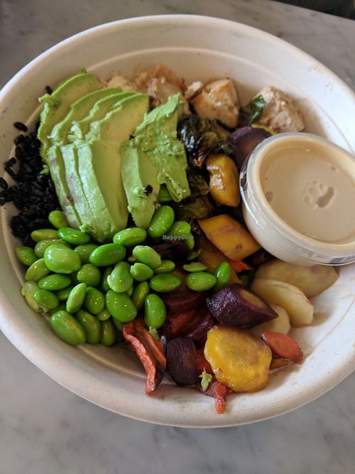 Vegan bowl with black forbidden rice, baked tofu, roasted root veggies, edamame, avocado, and tahini citrus miso dressing at Honest Mary's in Austin