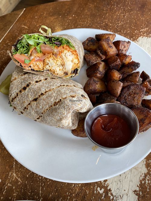 Buffalo cauliflower wrap and home fries￼  at Iron Roost in Ballston Spa