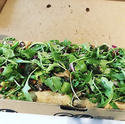 Pizza topped with a pile of arugula  at Zablong in Cincinnati