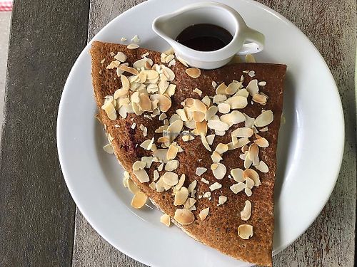Crepe filled with raspberry topped with roasted almonds and maple syrup separate at Gourmandise de Paris in Pyrmont