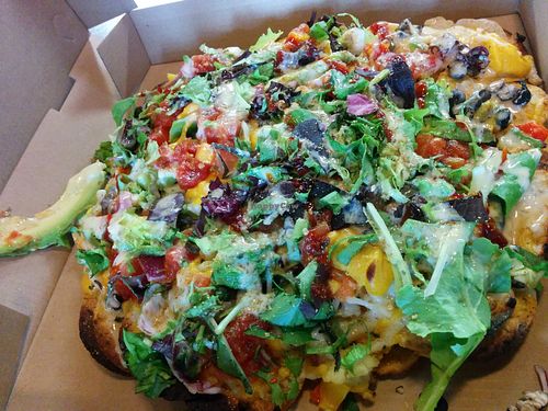 Picky Nikki Cauli Nachos. Wow - so good! Riced cauliflower, black beans, kale, avocado, mango salsa, chili sauce, cashew cheese, jalapenos, goddess dressing, sour cream on a bed of tortilla chips. at Dellz On The Macon in North Charleston