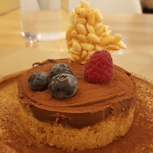 Chocolate dessert topped with a few berries and crispy rice. at Riz Riz - Marais in Paris