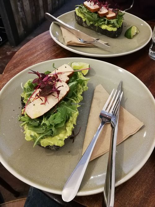 Smashed avocado toast topped with rocket, smoked tofu, and satay sauce at Filament Coffee in Edinburgh