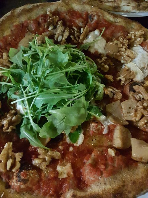 Personal pizza: almond Mozzarella with porcini mushrooms, walnuts, arrugula and help dough. 9 euros at Lore Pizzeria in Lecce