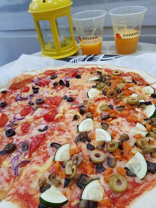 Left side with red onions, black olives, cherry tomato and garlic. Right side with sweet potato, grilled aubergine, zucchini, green olives. Both of sides with the 3 types of vegan  at Agvania Pizza in Limassol