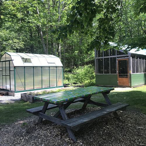 Outdoor seating with screened dining building in back at El El Frijoles in Sargentville