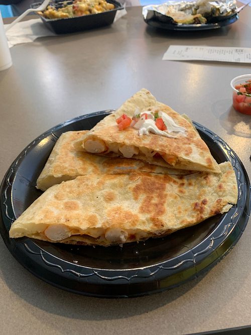 Side view of vegan shrimp quesadilla with vegan sour cream and salsa  at Guapo's Taco Shop in Bakersfield