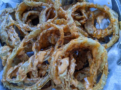 Cajun rings - thinly sliced onion rings in a well seasoned light batter with scallions, remoulade sauce at Houston Sauce Co in Houston