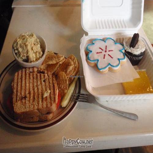 Pesto and vegan mozzarella panini. Sugar cookie, lemon square and cookies n' cream cupcake. at Sweetpea Baking Company in Portland