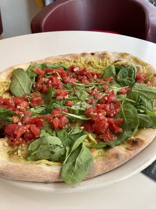 Vegan Pizza with basil pesto, vegan cheese, spinach & tomatoes at Vapiano in Linz