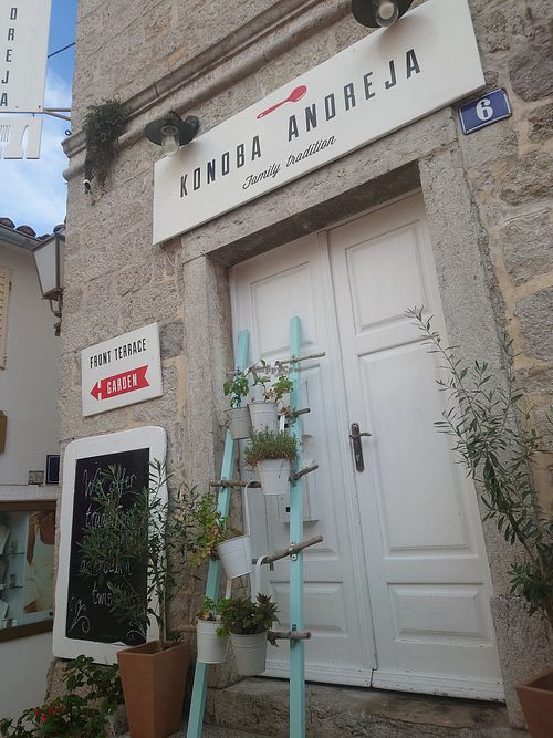 Door of the location behind the outside seating (out from the garden) - the sign arrow points to the direction which you can access the garden at Konoba Andreja in Krk