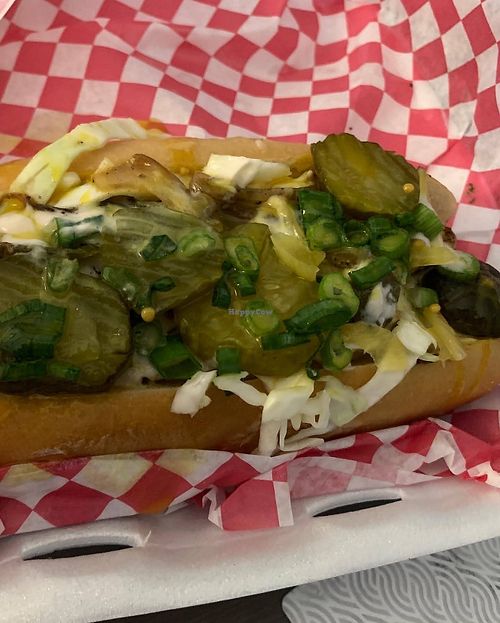 Vegan brat topped with slaw, onions, and pickles at Blue Sage Vegan Bistro in Little Rock