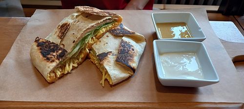Crunch-wrap: tortilla with pumpkin guacamole, vegan ham, vegan cheese, salad, and soy yoghurt at Palmovka in Prague