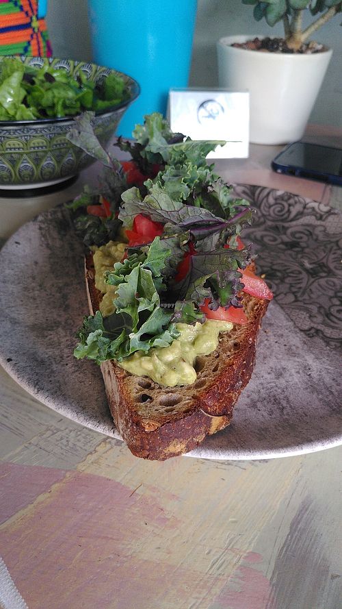 Smashed avocado on homemade sourdough bread and organic green salad at Avit in Athens