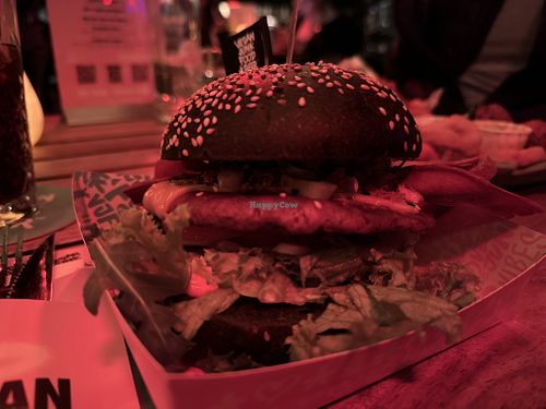  •	Royal Smash. Smashed Beef on Black Bun, cheese, bacon lettuce, tomato, pickle, jalapeño, hot cheese chick sauce     at Vegan Junk Food Bar - Downtown in Amsterdam