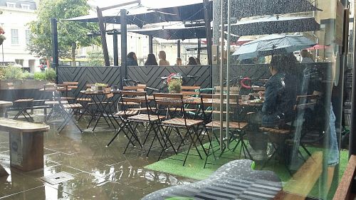 Eating in the rain. Parosols or a gazebo are needed! at Roots & Shoots Cafe in Bath