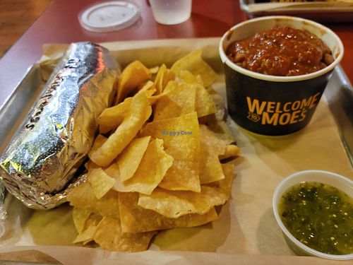 Burrito,  side of beans,  salsa and chips at Moe's Southwest Grill - Naples Blvd in Naples