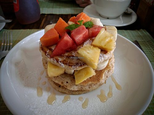 Stack of vegan pancakes with mixed fruit and maple syrup at Ganita Cafe in Pai