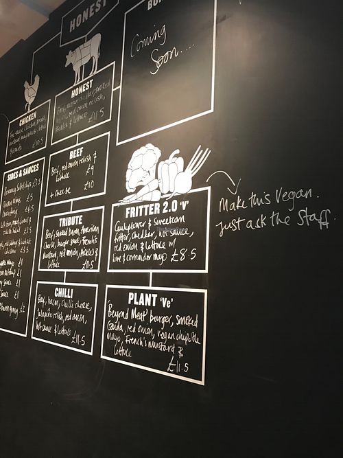 The wall at the entrance clearly shows all the vegan options. at Honest Burgers in London