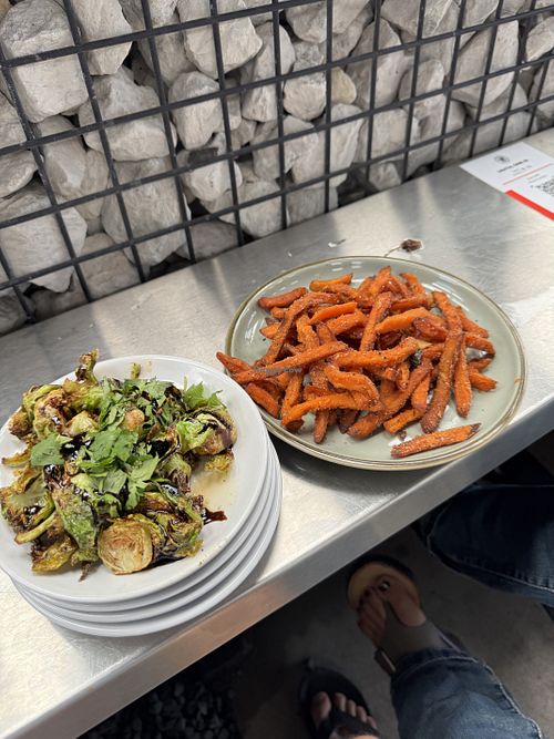 À la  carte sweet potato fries and the fried/glazed Brussels sprouts. Beyond burgers also available to sub on their burgers. Beer not pictured  at Bird Creek Burger Co in Temple