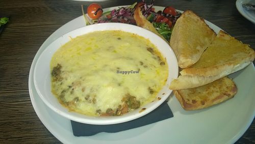 Lentil moussaka with grilled aubergines, béchamel sauce, vegan cheese, Mediterranean salad and garlic bread slices  at Evan's Bistro in Whitley Bay