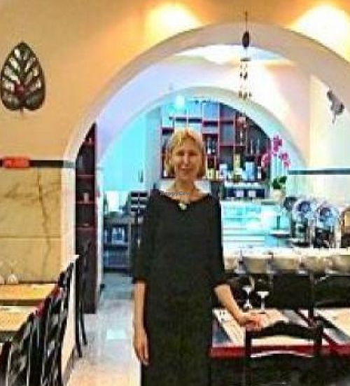 The very nice hostess at the wonderful Jardim das Cerejas with a 
bountiful buffet and diplomatic vegan chocolate salami in the background. at Jardim das Cerejas - Chiado in Lisbon