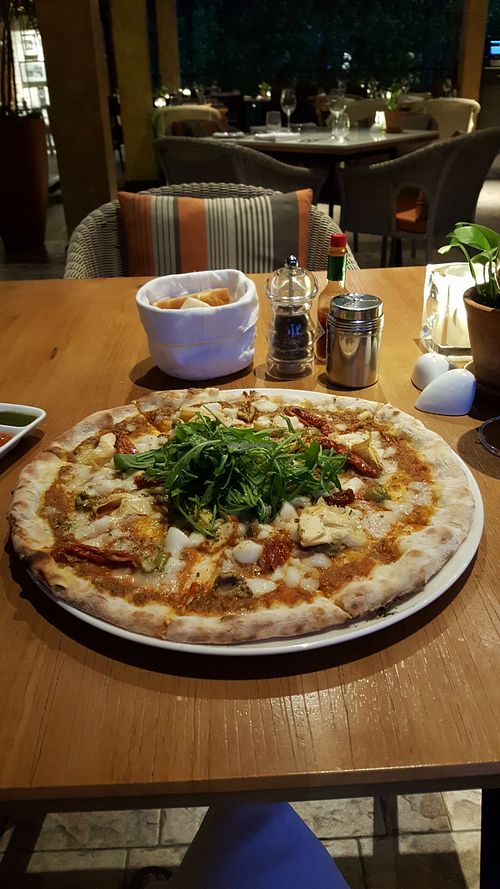 Thin-crusted pizza with olives, sun dried tomatoes, artichoke, and rocket, topped with vegan mozzarella. You choose the ingredients. at Prego in Koh Samui