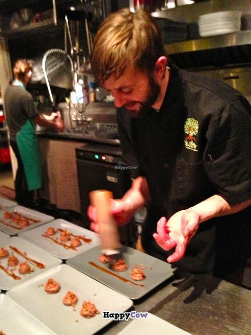Chef Patterson decorates the plated Rose-Chocolate-Coconut Mousse. at Sutra in Seattle