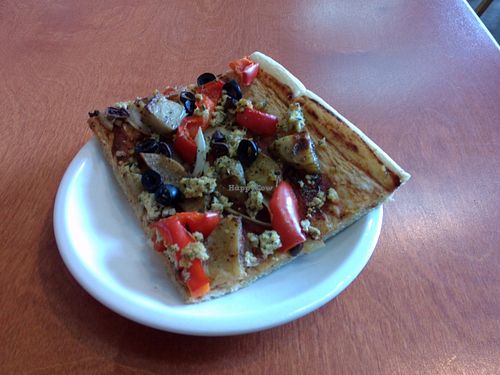 Pizza slice with potatoes and scrambled tofu. at Alpine Bakery in Whitehorse