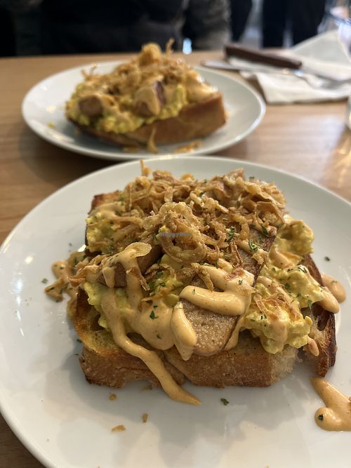 Scrambled tofu on toast, Swedish sausage, harrisa mayo and crispy onions   at Dauns in East London