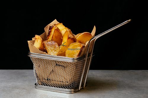 Baked Potatoes - fresh potatoes from the garden, cutted with peel and sauté in the oven with rosemary and poached garlic  at WellDone Burger in Ferrara