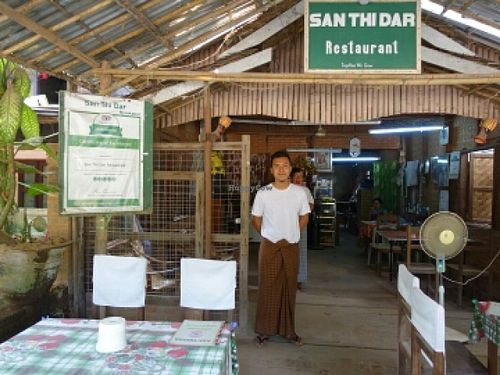 restaurant interior decor,  trip advisor excellent award and the boss's son at San Thi Dar Restaurant in Bagan
