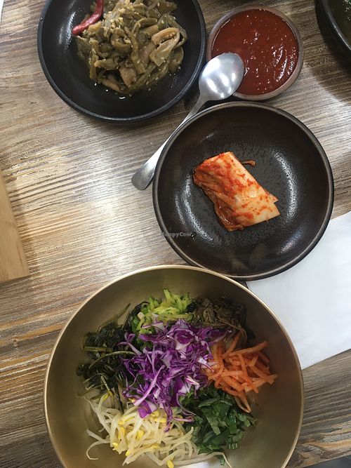 Seasoned taro root, gochujang, vegan kimchi and bibimbap in traditional tableware  at Babiboyak in Jeju