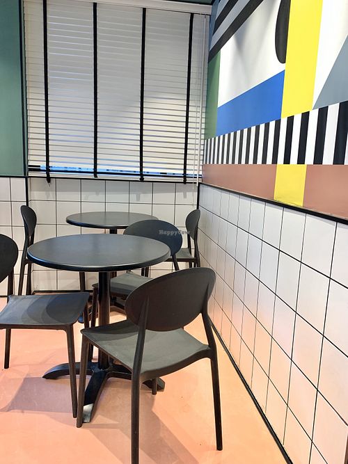 Seating in the colorful dining area - drink lemonade and think about the Bauhaus. at The Green Butcher in Tel Aviv