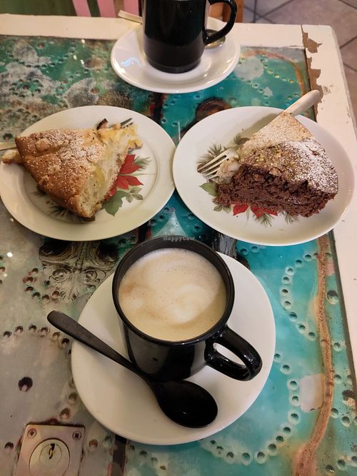 Homemade cakes (apple-nuts, pistachio-chocolate and pear) and (2x) cappuccino with soy milk. In total 9€ (2026!)  at Vin Love Café in Genoa