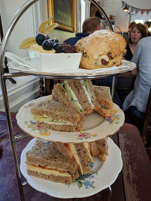 Afternoon Tea, top scone, butter jam, then cucumber and sourcream sandwich & cheese and tomato sandwich.  at Pettigrew Tea Rooms in Cardiff