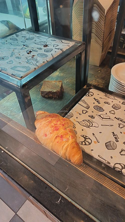 Fallen croissant and flapjack in the display cabinet. at Caffè Nero in Sherborne