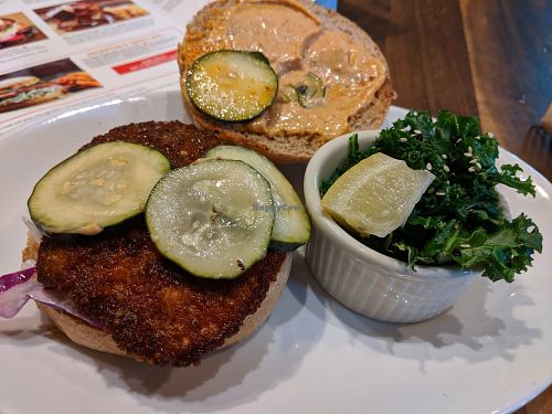 Real Nashville hot combo, chickn, hot sauce, slaw, pickle chips with side of steamed kale at Native Foods in Palm Springs