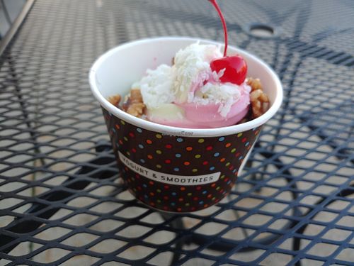 Orange Beet and Pineapple Spinach Fro no with coconut shreds, walnuts, and a cherry on top. at Red Mango in Fort Wayne