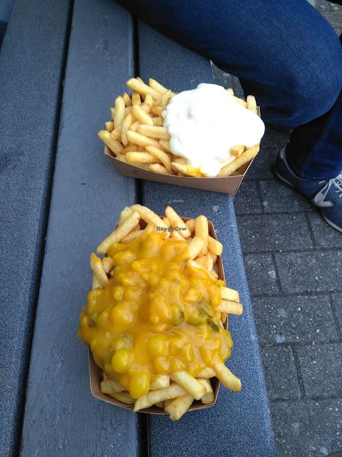 Big fries from Jorgen's one with pickle sauce (vegan) one with veganaise. On the nice bench across from the frituut.  at Jorgen's Friethuisje in Tienen