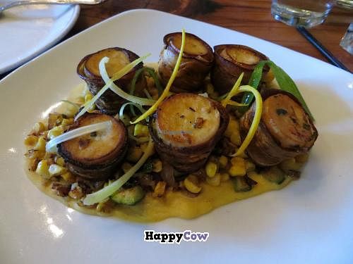 Vegan Scallops Wrapped in Bacon.  Chanterelle mushrooms wrapped in eggplant bacon on bed of corn, pepper and zucchini ragout.   at Portobello Vegan Trattoria in Portland