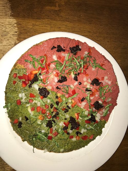 Raw pizza, half marinara and half pesto  at Peacefood Cafe - Uptown in New York City